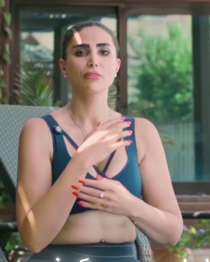 Samira Safari seated outdoors, hands resting at the heart